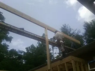 Carpenter setting a ridge beam over a new addition frame — Ice Dam Removal by Roofing Brothers in Wrentham