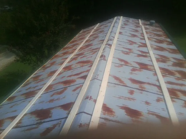 Rusted metal roof panels with new wood purlins before replacement — Storm Damage Roof Repair in Wrentham by Roofing Brothers