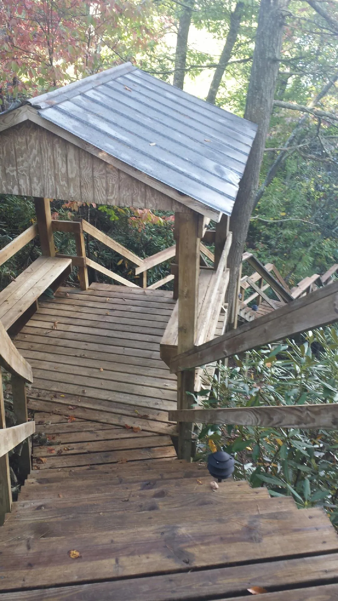 Metal roofed shelter over wooden steps on a wooded walkway — Skylight Repair & Installation work by our crew in Wrentham