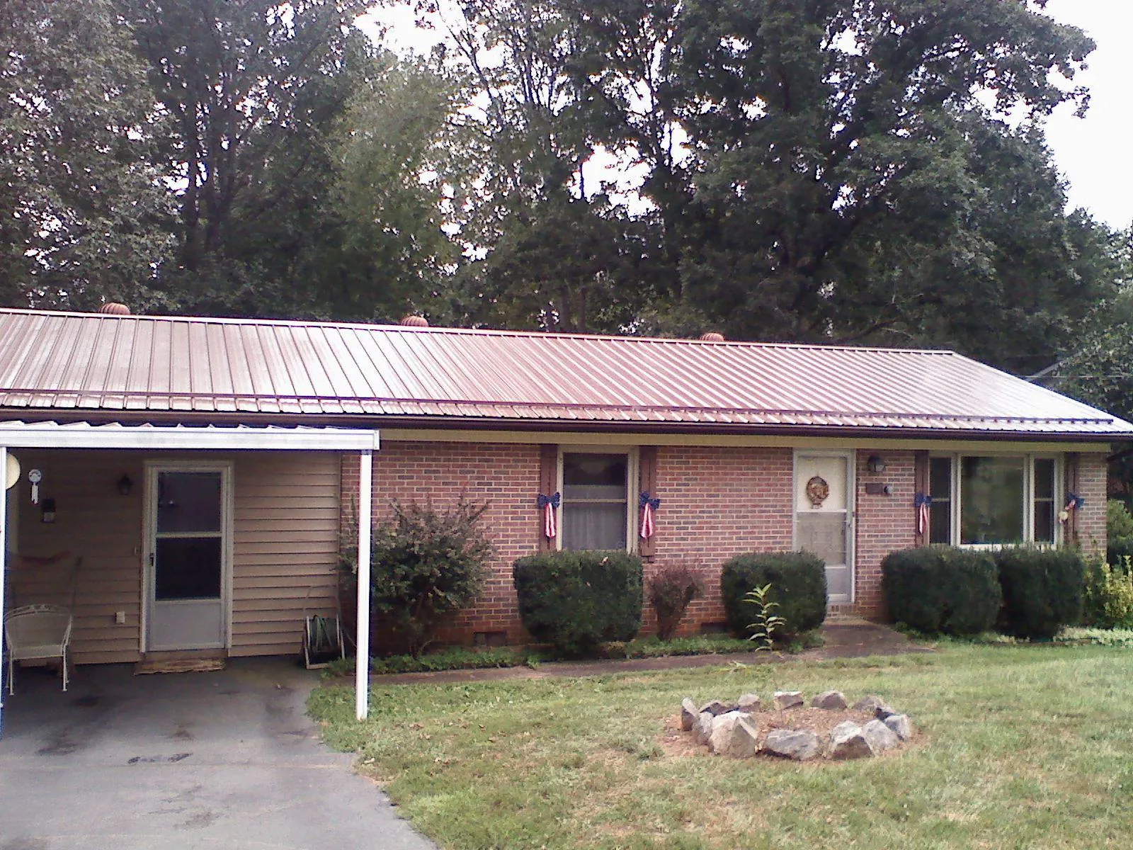 Bronze metal roof and carport on a brick ranch home — Roof Repair work by our crew in Wrentham